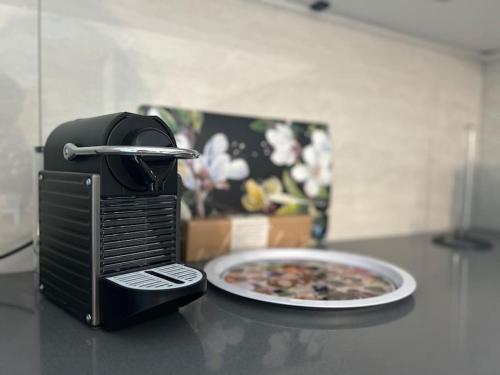 a toaster on a counter next to a plate of pizza at LabPark Luxury Apartment in Melano