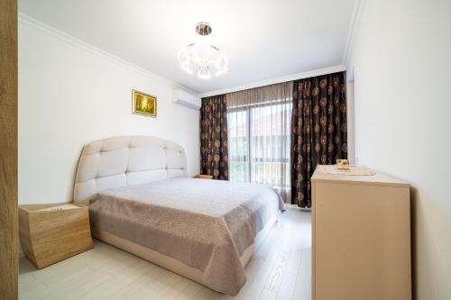 - une chambre avec un lit et une grande fenêtre dans l'établissement Grand Karavel Top Center Lux Apartment, à Varna