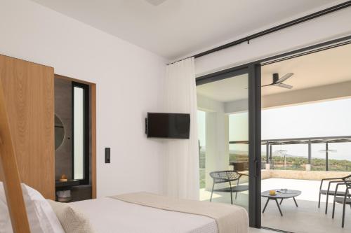 a bedroom with a bed and a tv on a wall at Caelum Villa, By Hellocrete in Píkris