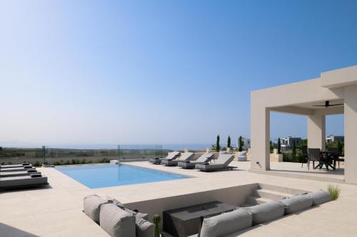 a villa with a swimming pool and lounge chairs at Caelum Villa, By Hellocrete in Píkris