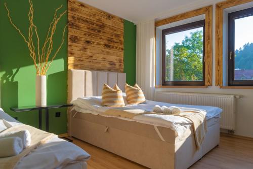 a bedroom with green walls and a bed with pillows at ABA Apartamenty Comfort Family in Krynica Zdrój