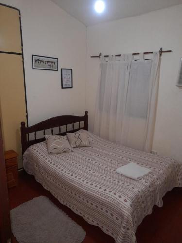 1 dormitorio con 1 cama con manta blanca y ventana en Apart incone en Formosa