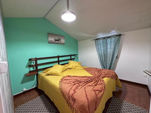 a bedroom with a bed and a green wall at Casa da Nogueira in Porto Moniz