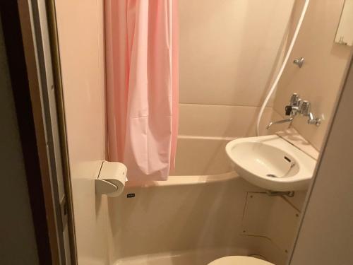 a small bathroom with a sink and a toilet at Casa Viento Stay Inn in Hiroshima
