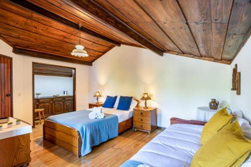 a bedroom with two beds and a wooden ceiling at Chalé da Caniçada By Sé Apartamentos in Rio Caldo