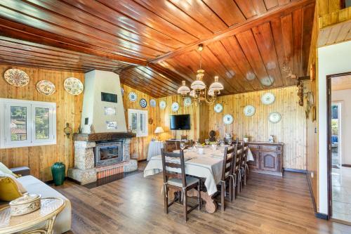 a dining room with a table and a fireplace at Chalé da Caniçada By Sé Apartamentos in Rio Caldo