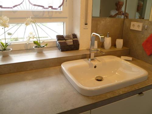 a white sink in a bathroom with a window at Villa Xadayu in Reichenau