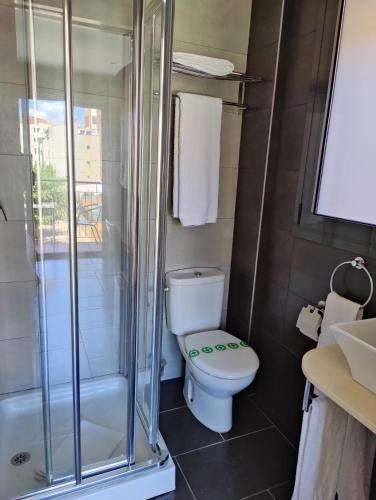 a bathroom with a toilet and a shower at Hostal Manel in Pineda de Mar
