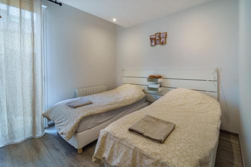 two twin beds in a room with a window at Maison calme avec terrasse/garage centre-ville C in Dijon