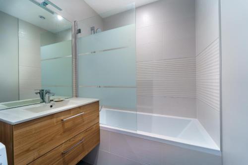 La salle de bains est pourvue d'une baignoire, d'un lavabo et d'une douche. dans l'établissement Maison calme avec terrasse/garage centre-ville C, à Dijon