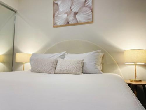 a bedroom with a white bed with two pillows at Cultural Oasis Kingbed Apt at South Bank in Brisbane