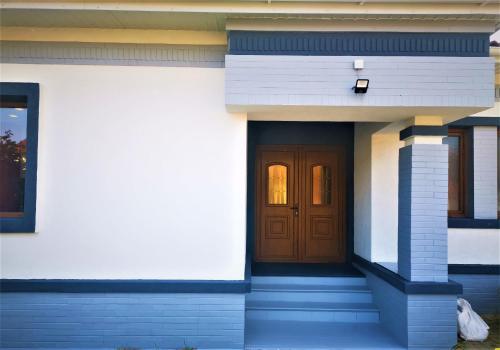 una casa con una puerta marrón y escaleras en NETFLIX & CHILL, en Remetea Mare