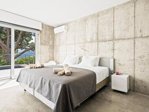 a bedroom with a large bed with two stuffed animals on it at Design villa sea views and lap pool in Cabrils