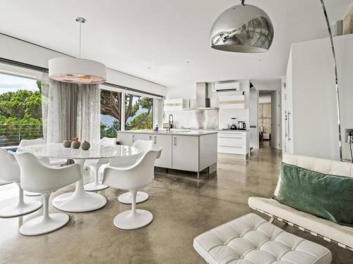 a kitchen and living room with a table and chairs at Design villa sea views and lap pool in Cabrils