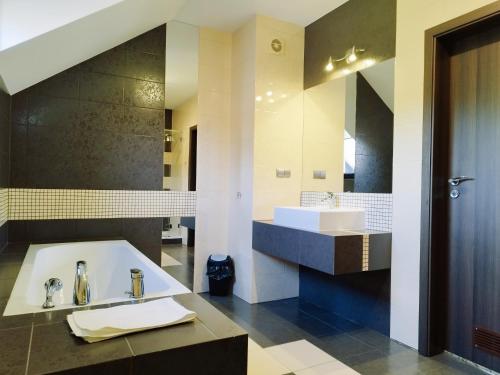 La salle de bains est pourvue d'un lavabo et d'un grand miroir. dans l'établissement Hotel Cykada, à Wielki Głęboczek