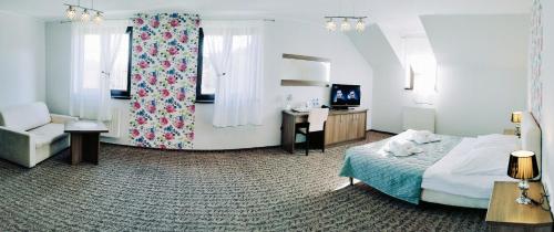um quarto com uma cama, uma cadeira e uma secretária em Hotel Cykada em Wielki Głęboczek