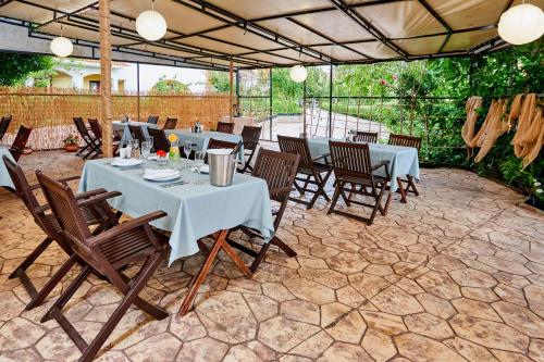 a restaurant with white tables and chairs and lights at Hotel Fara - Marina Cape in Aheloy