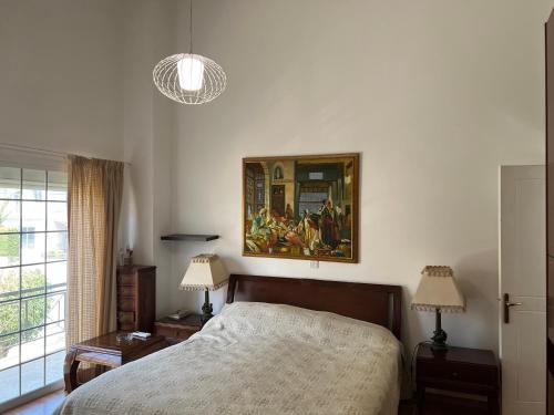 利馬索爾的住宿－Villa Sawa by Ezoria Villas，卧室配有一张床,墙上挂有绘画作品
