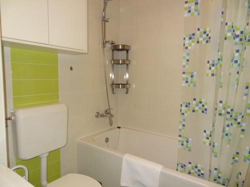 a bathroom with a white toilet and a shower at Well-equipped apartment with free parking in Zagreb