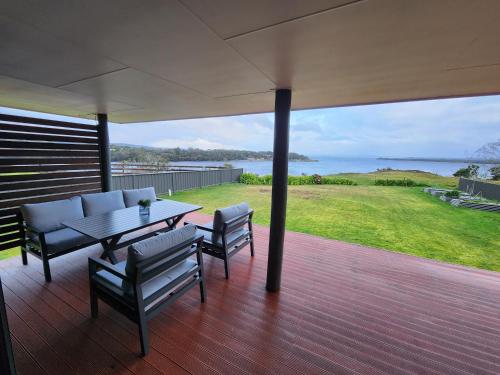 a patio with a table and chairs on a deck at Bayviews in Strahan