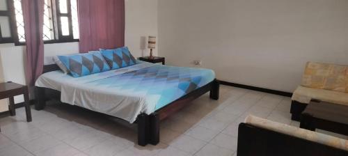 - une chambre avec un lit doté d'oreillers bleus dans l'établissement Holiday studio, à Ukunda
