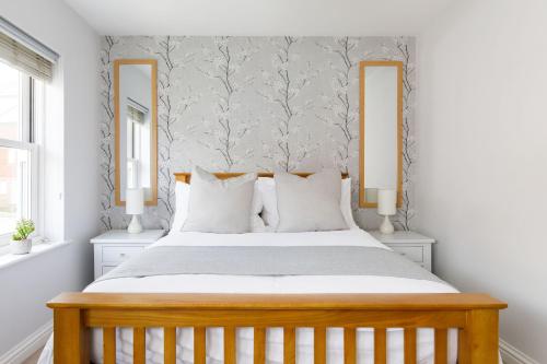 a bedroom with a large bed with two mirrors at Castle Bank Terrace in Lewes