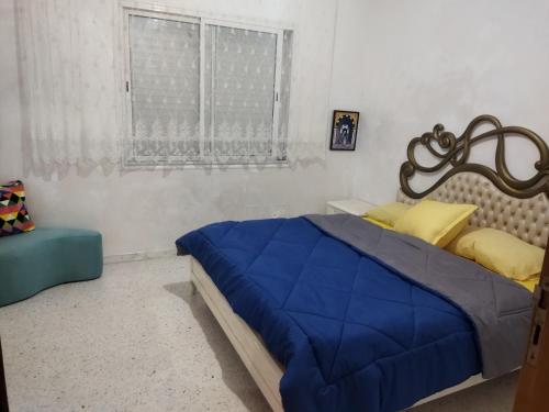 a bedroom with a blue bed and a window at cozy appartement D6 in Hammamet