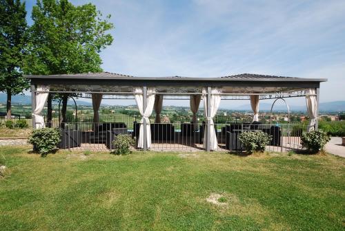 a gazebo with white curtains on it in a park at Spoleto by the pool in Spoleto