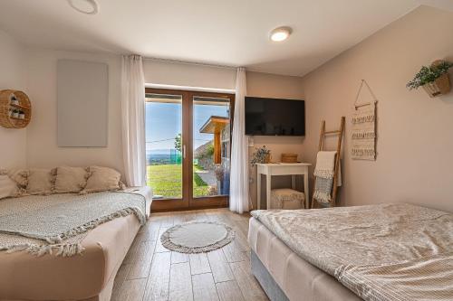 1 dormitorio con cama y ventana grande en Vineyard Cottage Lan On The Hill - Happy Rentals, en Semič