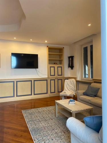 ein Wohnzimmer mit einem Sofa und einem TV an der Wand in der Unterkunft Benvenuto Beach House in Monterosso al Mare