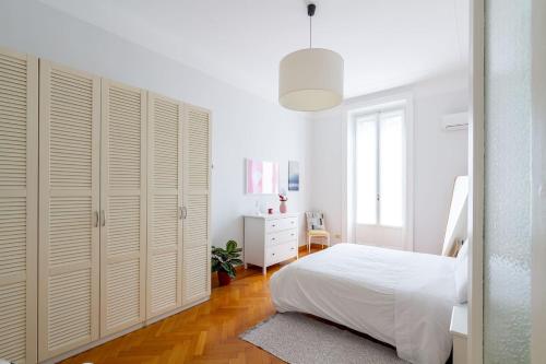 a white bedroom with a bed and a white cabinet at Liberty Home in Milan