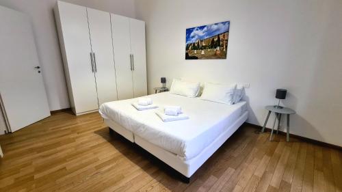 1 dormitorio con 1 cama blanca y 2 toallas en Ritter'S Rooms & Apartments, en Trieste