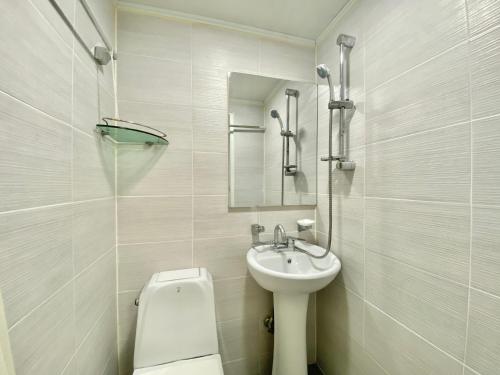 Baño blanco con lavabo y aseo en JIBIDA Urban Inn en Seúl