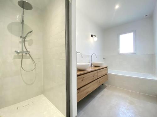 une salle de bain blanche avec deux lavabos et une douche dans l'établissement Villa neuve bardée en bois avec piscine chauffée, à Gujan-Mestras