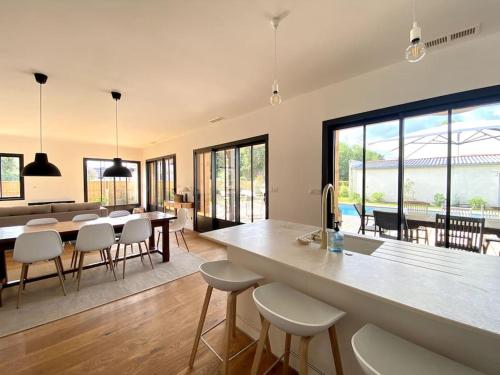 une cuisine et un salon avec une table et des chaises dans l'établissement Villa neuve bardée en bois avec piscine chauffée, à Gujan-Mestras