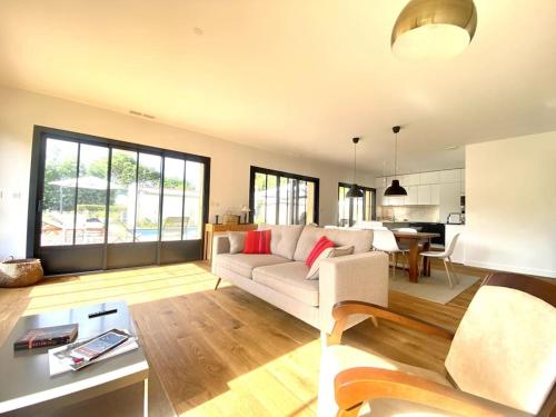 un salon avec un canapé blanc et une table dans l'établissement Villa neuve bardée en bois avec piscine chauffée, à Gujan-Mestras