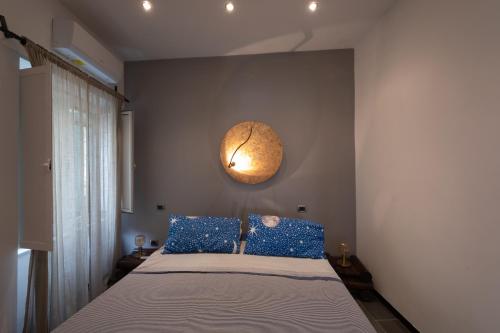 a bedroom with a bed with blue pillows and a clock at Palazzo Monterone in Forio d'Ischia