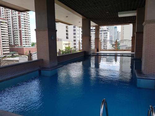 a swimming pool in a building with blue water at Hospital ng Manila front delux le mirage de malate in Manila