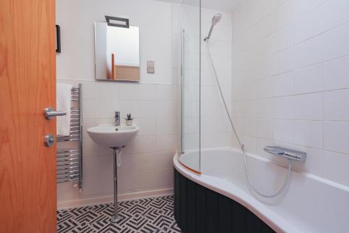 a bathroom with a tub and a sink and a shower at Regency Stables in Brighton & Hove