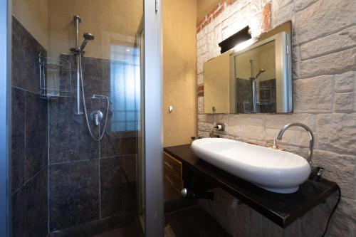 a bathroom with a sink and a shower with a mirror at Palazzo Monterone in Forio d'Ischia