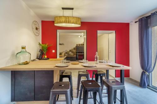 a kitchen with a large wooden table and stools at Maisons calmes avec terrasses et garages centre-ville B et C in Dijon