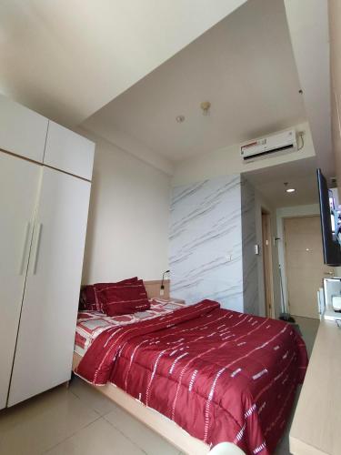 - une chambre avec un lit et une couverture rouge dans l'établissement Treepark bsd serpong By SM ROOM, à Dadap
