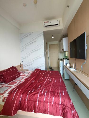 - une chambre avec un grand lit rouge et une télévision dans l'établissement Treepark bsd serpong By SM ROOM, à Dadap