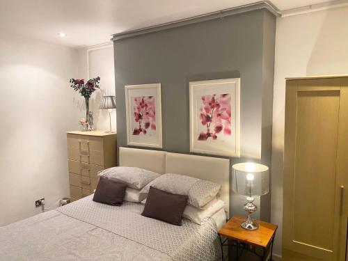 a bedroom with a bed and two pictures on the wall at Solomons Peak Apartment in Buxton