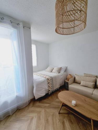 une chambre avec un lit, un canapé et une table dans l'établissement studio avec vue sur mer, à Saint-Hilaire-de-Riez