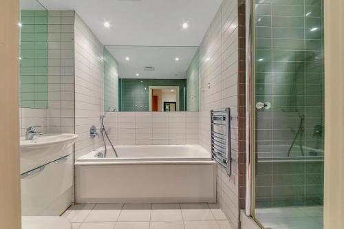 uma casa de banho com uma banheira, um lavatório e um chuveiro em ComfyCozy Luxury Apartment Canning Town em Londres