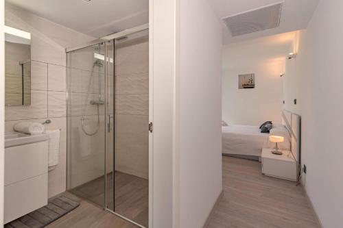 a bathroom with a glass shower and a bed at Villa Tania in Can Picafort