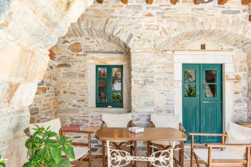 a room with a table and chairs and a stone wall at Zeus House in Philotium