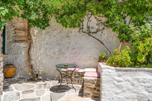 a patio with a table and chairs under a tree at Zeus House in Philotium
