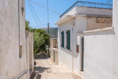 an alley with white buildings and green shutters on at Zeus House in Philotium